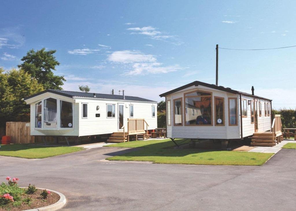 two mobile homes are parked in a parking lot at Cowden Holiday Park in Great Cowden