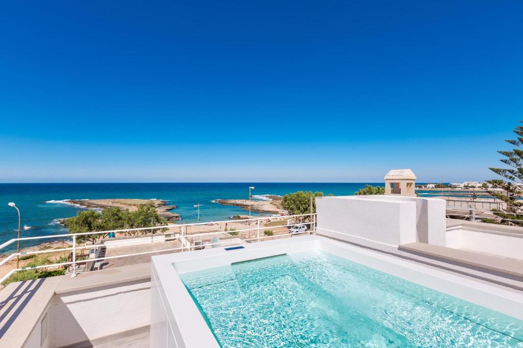 a swimming pool on top of a building with the ocean in the background at Attico Mezzaluna by BarbarHouse in Torre Santa Sabina