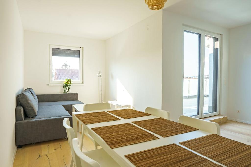 een eetkamer met een tafel en een bank bij Vienna Living Apartments - Hadrawagasse in Wenen