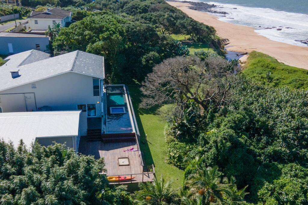 an aerial view of a house and the ocean at Splash Rock Beachfront Villa in Umtentweni