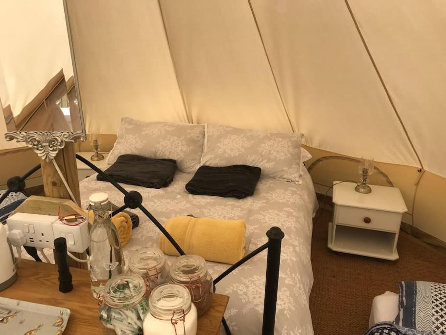 ein kleines Zimmer mit einem Bett in einem Zelt in der Unterkunft Cox Hill Glamping Badger in Truro