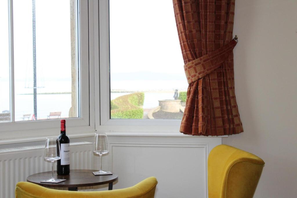 a table with a bottle of wine and two glasses at The Crown Hotel in Morecambe