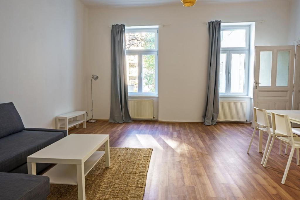 ein Wohnzimmer mit einem Sofa und einem Tisch in der Unterkunft Vienna Living Apartments - Müllnergasse in Wien