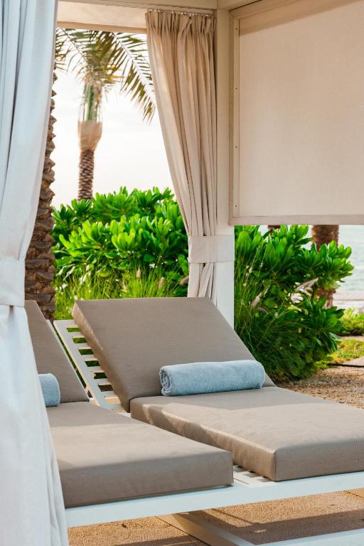 two beds on a porch with a view of the ocean at ERTH Abu Dhabi Hotel in Abu Dhabi