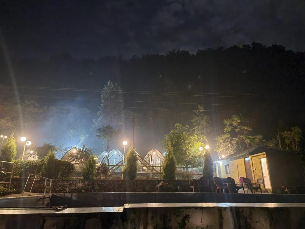 um grupo de edifícios à noite com luzes em Aita River Resort em Dogadda