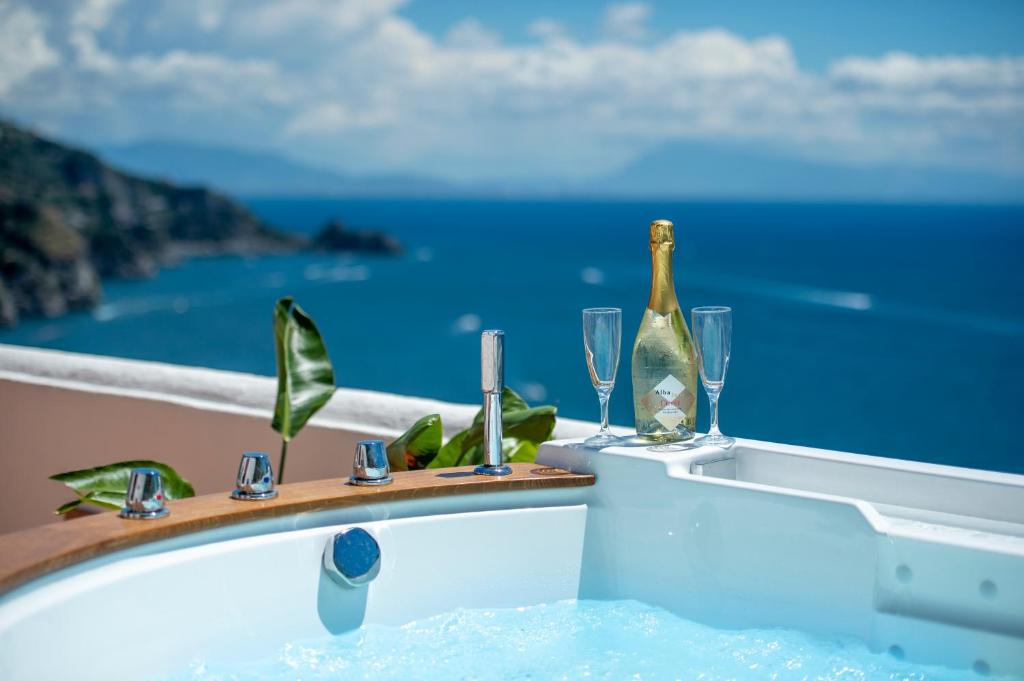 een bad met een fles wijn en glazen bij Casa Albatros in Praiano