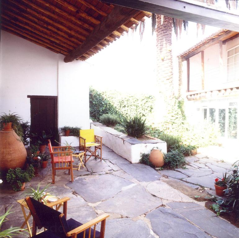 a patio with chairs and tables in a house at Posada de Amonaria in Malpartida de Plasencia