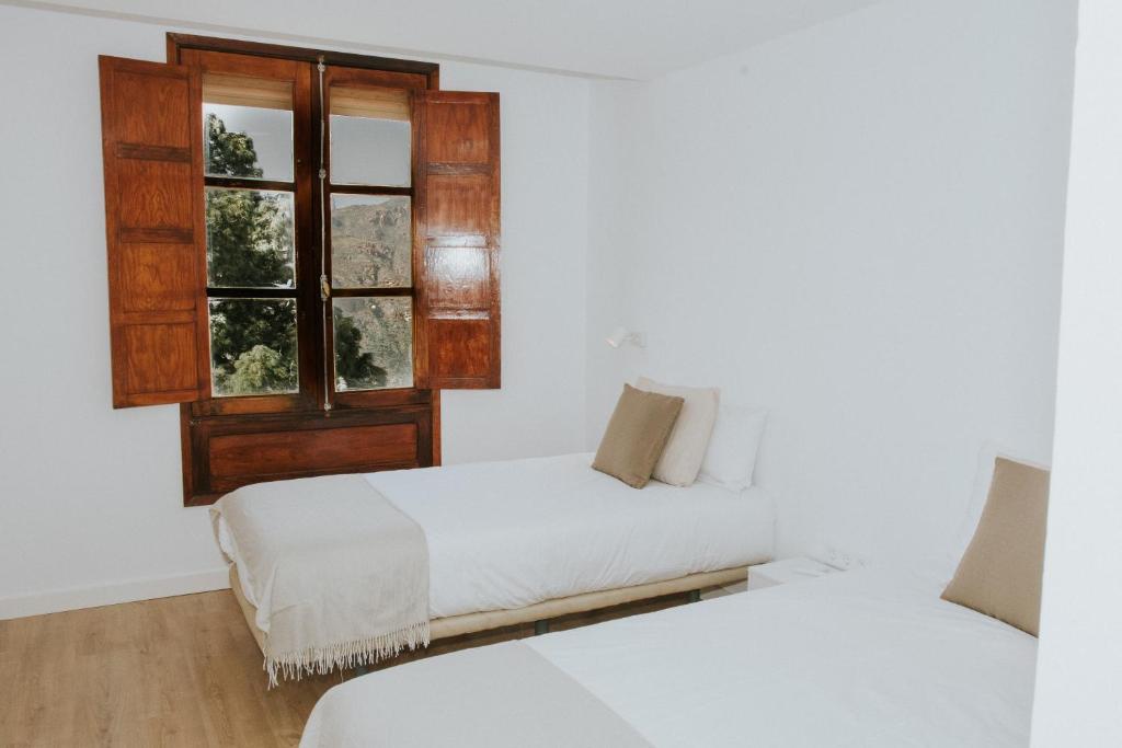 una camera con due letti e una finestra di Texeda Room Suites a Tejeda