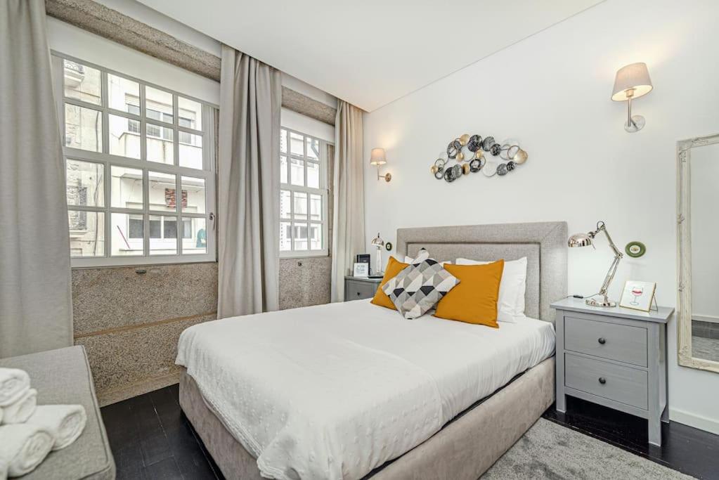een slaapkamer met een groot bed met gele kussens bij Sandeman's Apartment by Innkeeper in Vila Nova de Gaia