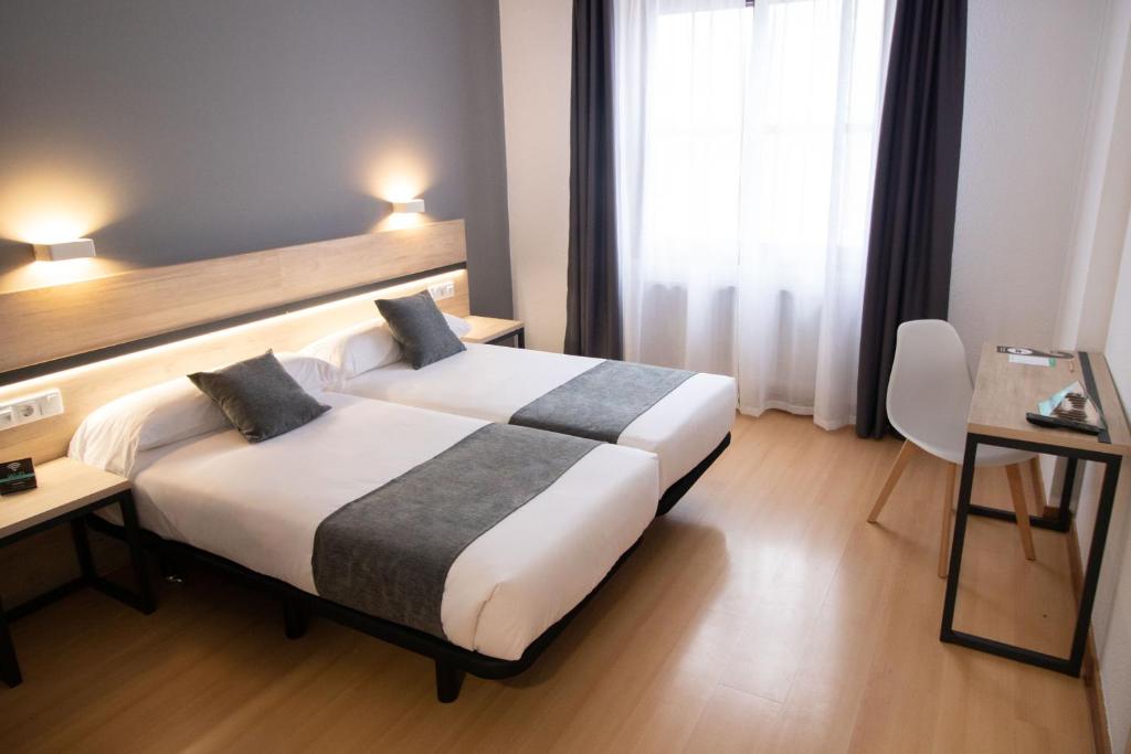ein Hotelzimmer mit einem großen Bett und einem Fenster in der Unterkunft Alda Puerto Seco in Burgos