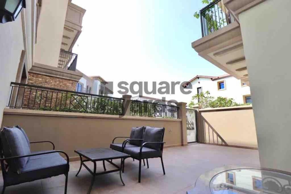 a balcony of a condo with chairs and a table at Luxurious 1 bed Apt with Outdoor Patio - Madinat Badr in Dubai