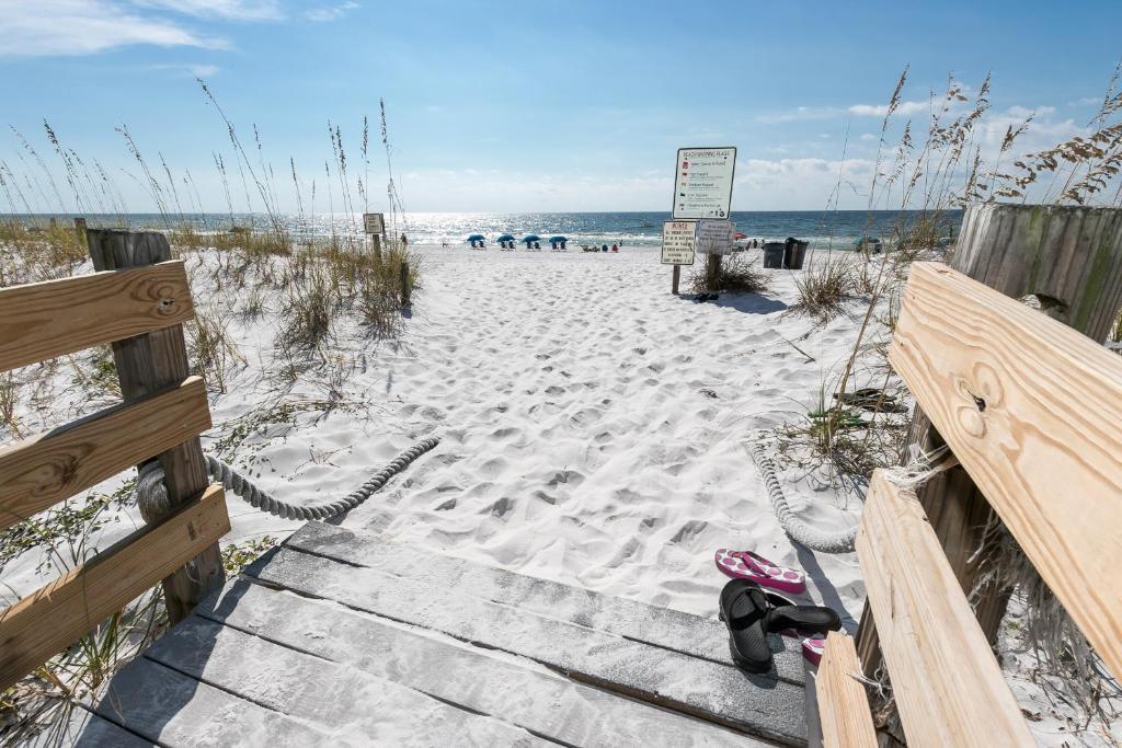 a stairway to the beach with a sign in the sand at SO 101 - Large 3 BR Beachfront Ground Floor Condo in Fort Walton Beach