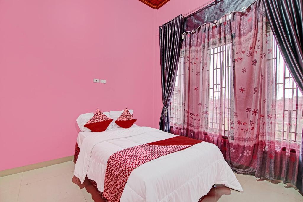 En eller flere senge i et værelse på OYO 92177 Arafah Homestay Syariah