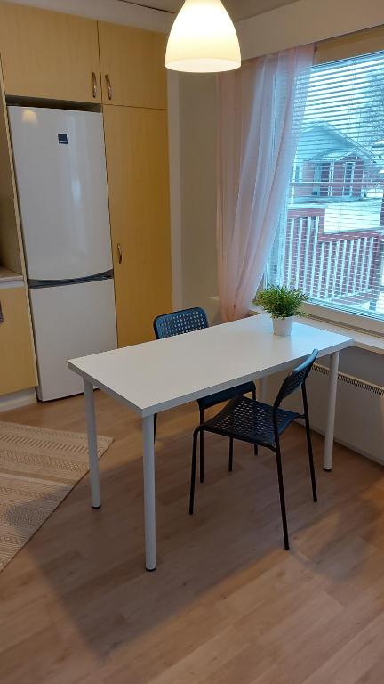 a white table and two chairs in a room with a window at Apartment Lapväärtti, kaksio in Lapväärtti