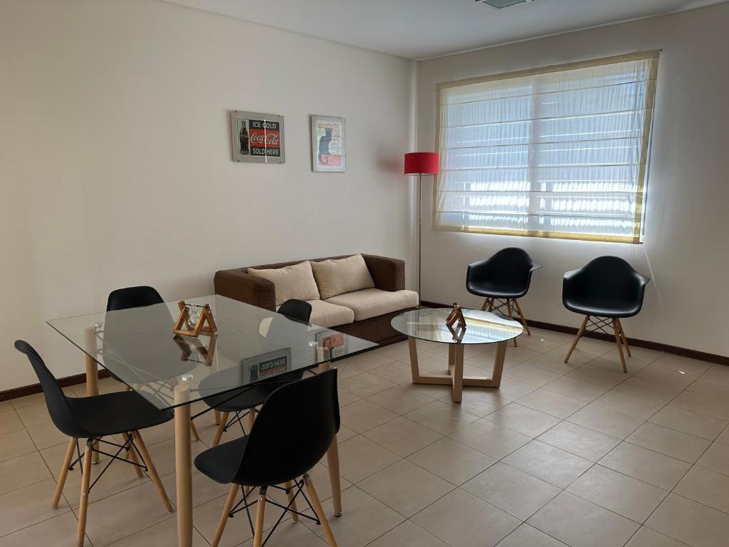 - un salon avec une table et des chaises en verre dans l'établissement Departamento Quinta N, à Mendoza