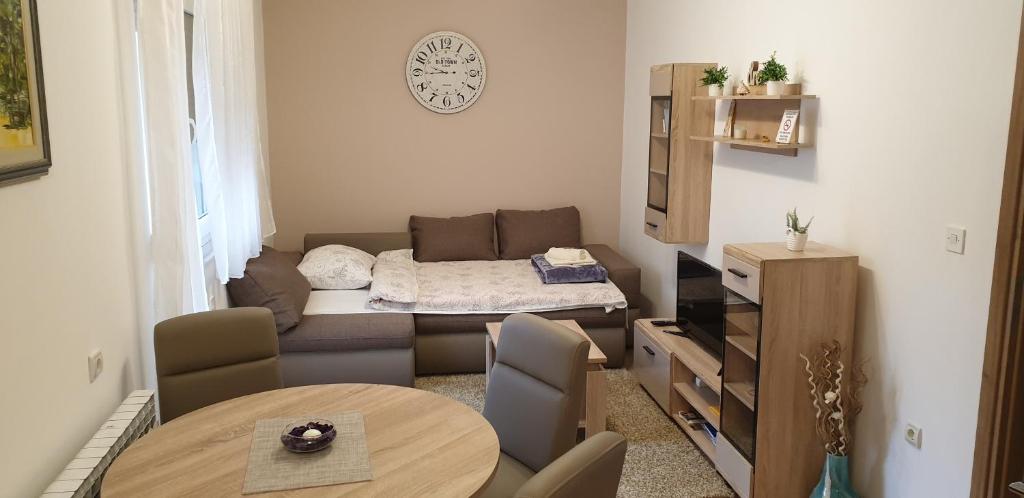 a small living room with a bed and a table at Apartman SAN in Vukovar