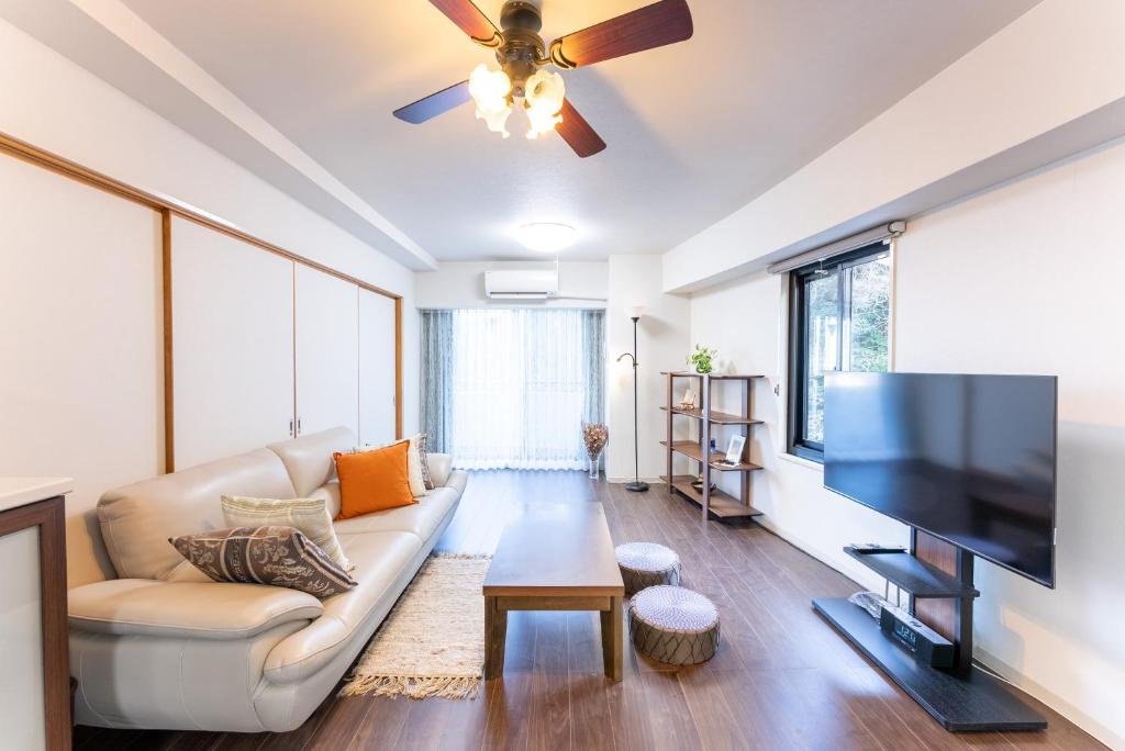 a living room with a couch and a flat screen tv at VIVI熱海 自然郷 3001丨VIVI Atami Shizenkyo 3001 in Atami
