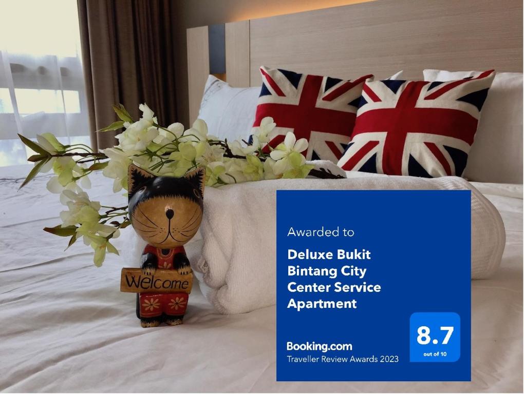 a teddy bear sitting on top of a bed at Deluxe Swiss Garden Residences Bukit Bintang City Center in Kuala Lumpur