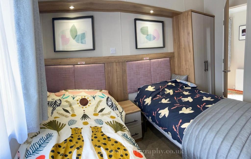 a bedroom with a bed in a room with two pictures on the wall at 18 Duckpool in Kilkhampton