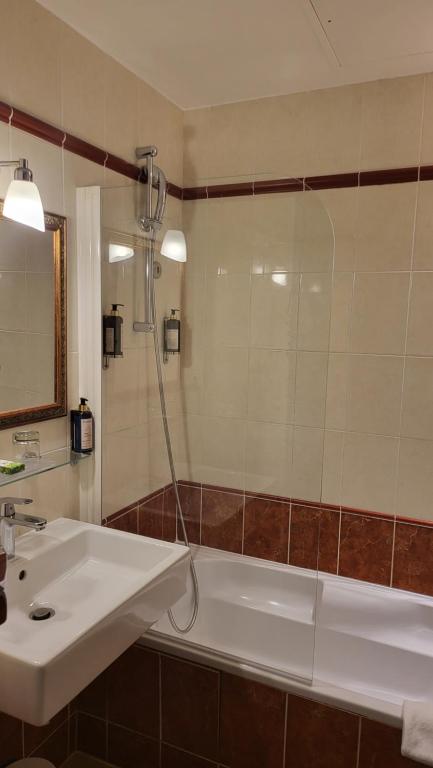 a bathroom with a white tub and a sink at Magda Champs Elysées in Paris