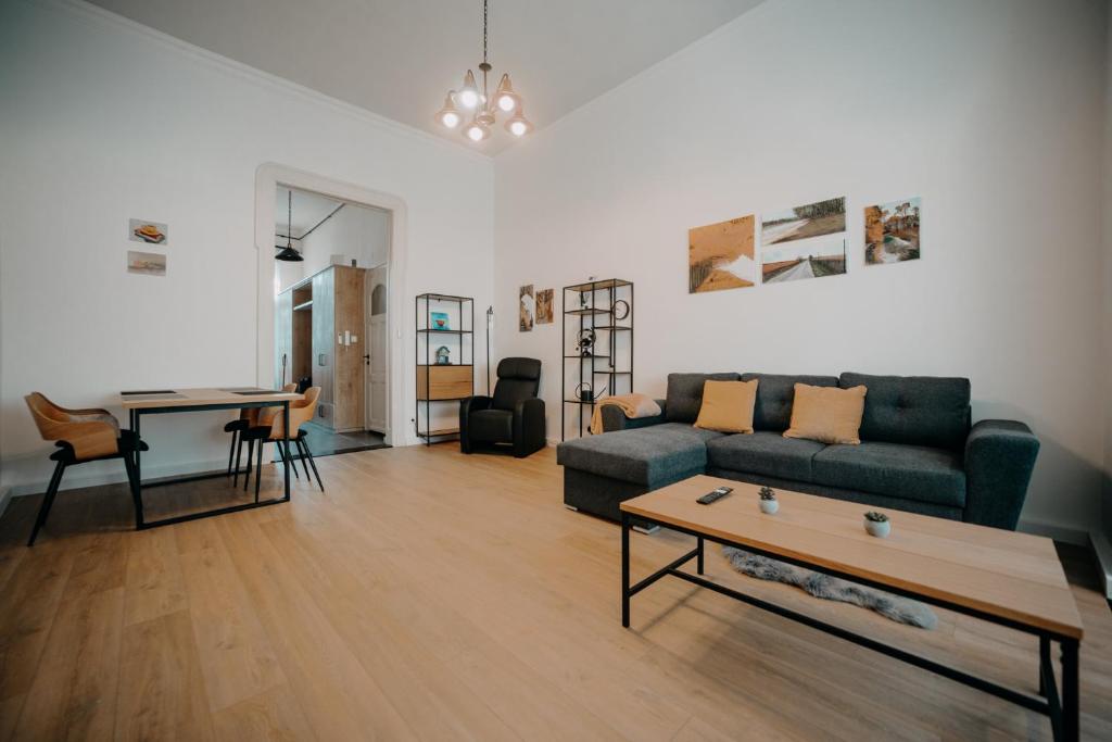 uma sala de estar com um sofá e uma mesa em Volenter Lux Apartment Zero em Baja
