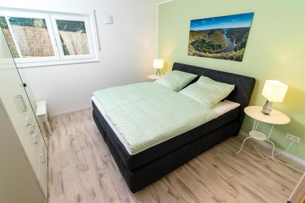 a bedroom with a black bed and a window at Ferienwohnung Landurlaub in Irsch