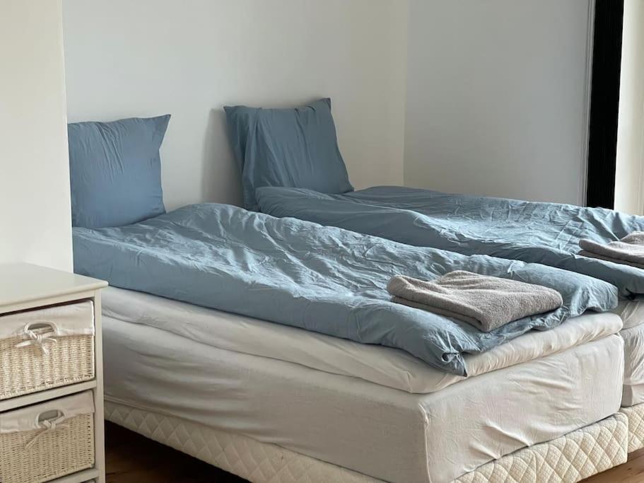 uma cama com lençóis azuis em cima em Central lejlighed i Herning em Herning