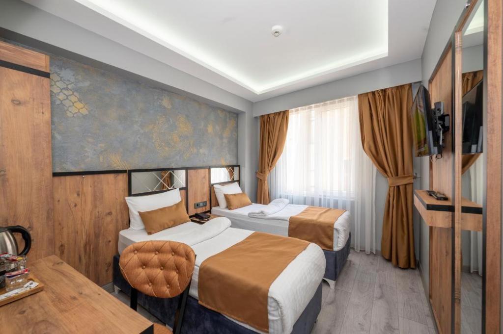 a hotel room with two beds and a table at Vizyon Hotel in Istanbul