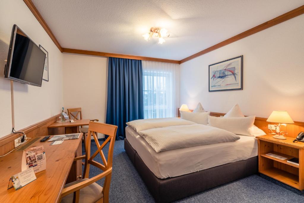 a hotel room with a bed and a desk at AKZENT Hotel Frankenberg in Frankenberg