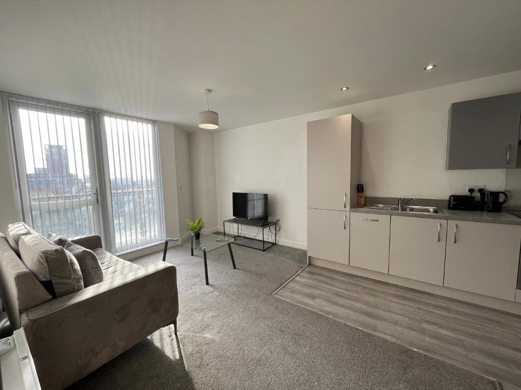 a living room with a couch and a kitchen at Modern 1 Bedroom Apartment Central Manchester in Manchester