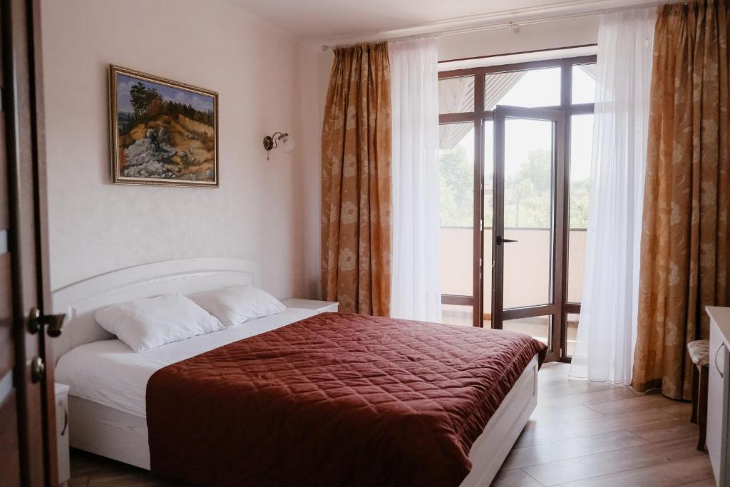 a bedroom with a bed and a large window at Готель Хутір in Malyye Khutora