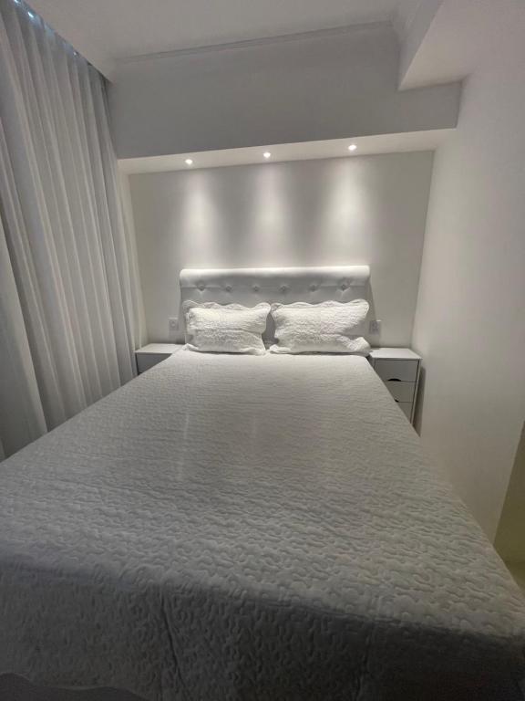 1 dormitorio con 1 cama grande y 2 almohadas blancas en Suite privada, en Salvador