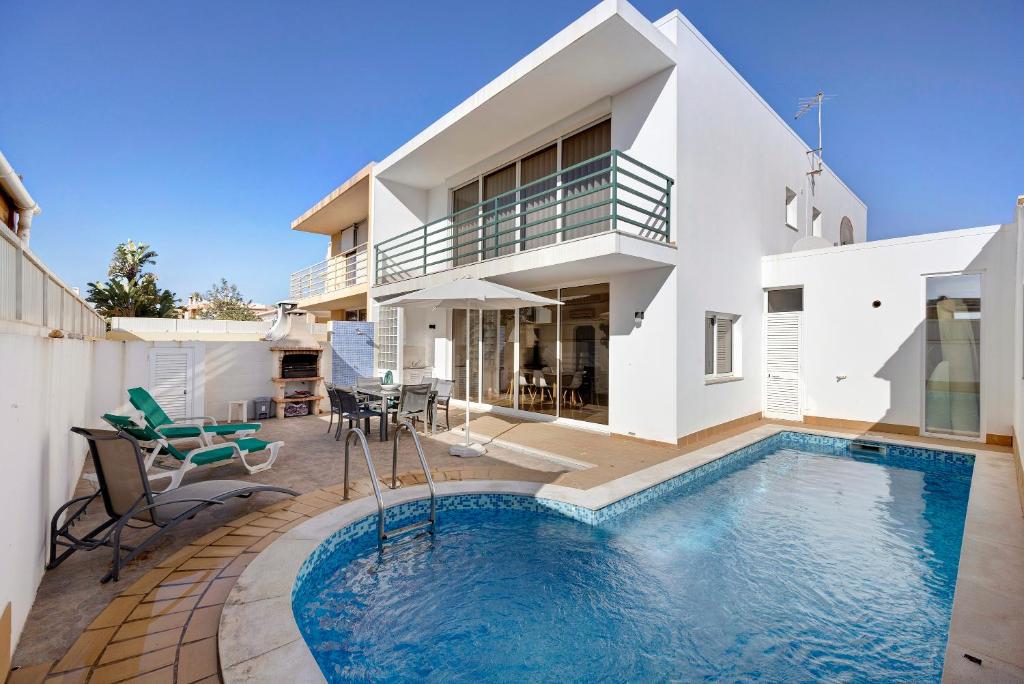 a villa with a swimming pool in front of a house at Lagos Beach Pool Villa in Lagos