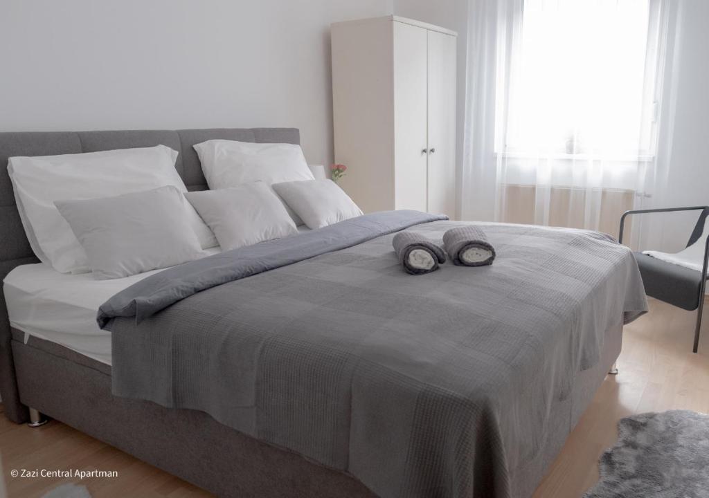 a bed with two towels on top of it at Central Apartman, Belváros Lakás in Kecskemét