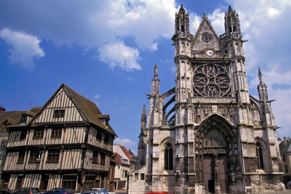 an old church with a clock tower in a city at Appt cosy coeur historique+park, 5mn gare Vernon in Vernon