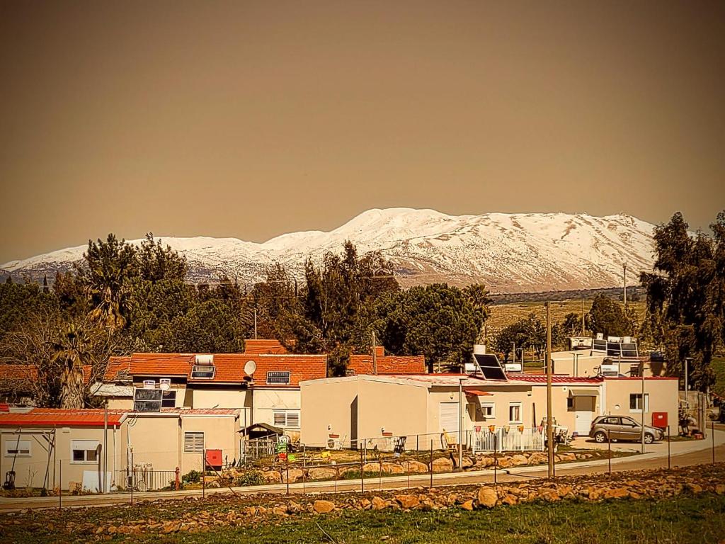 una ciudad con montañas cubiertas de nieve en el fondo en Luxury family caravan truck in the Golan Heights, en Bruchim Qela' Alon