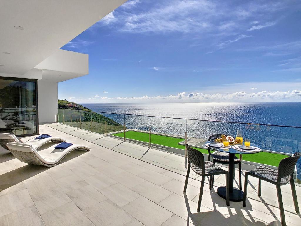 a balcony with a table and chairs and the ocean at Francelho 2 Aparment by MHM in Ribeira Brava
