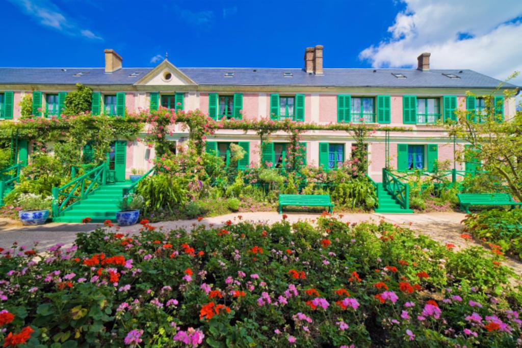 a large house with flowers in front of it at Appt cosy coeur historique+park, 5mn gare Vernon in Vernon