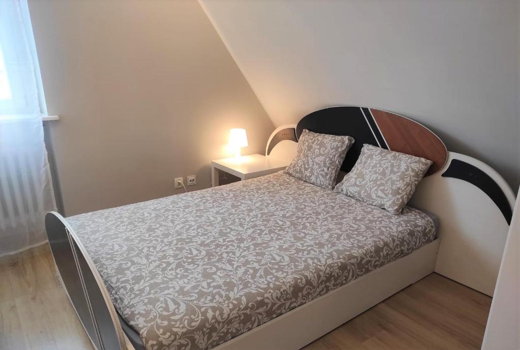 a small bedroom with a bed with a wooden headboard at Rynek 11 in Poznań