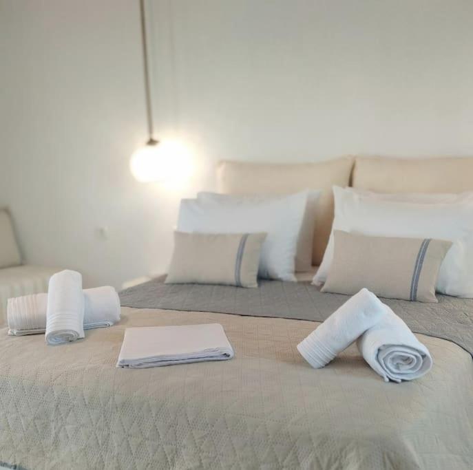 un grande letto con asciugamani e cuscini sopra di Orion Milos a Pollonia