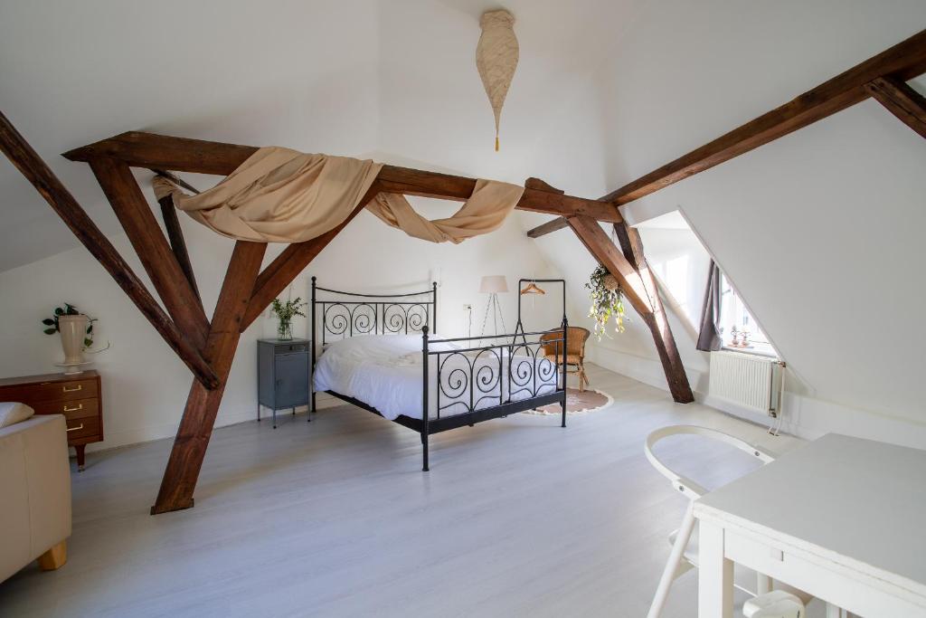 een slaapkamer met een bed in een kamer met houten balken bij De Hilde in Zutphen