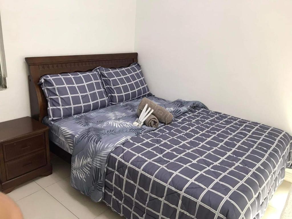 a bedroom with a bed with a blue and white comforter at Birch tower by matthqueenroom, malate in Manila