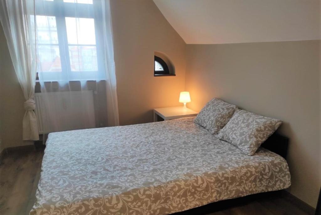 sypialnia z łóżkiem i oknem w obiekcie Rynek 10 w Poznaniu
