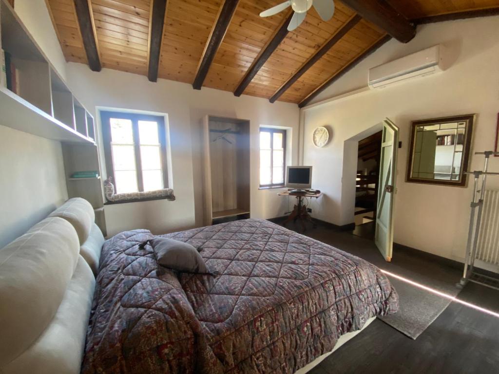 1 dormitorio con 1 cama grande en una habitación con ventanas en La corte di Bacco, en Maniago