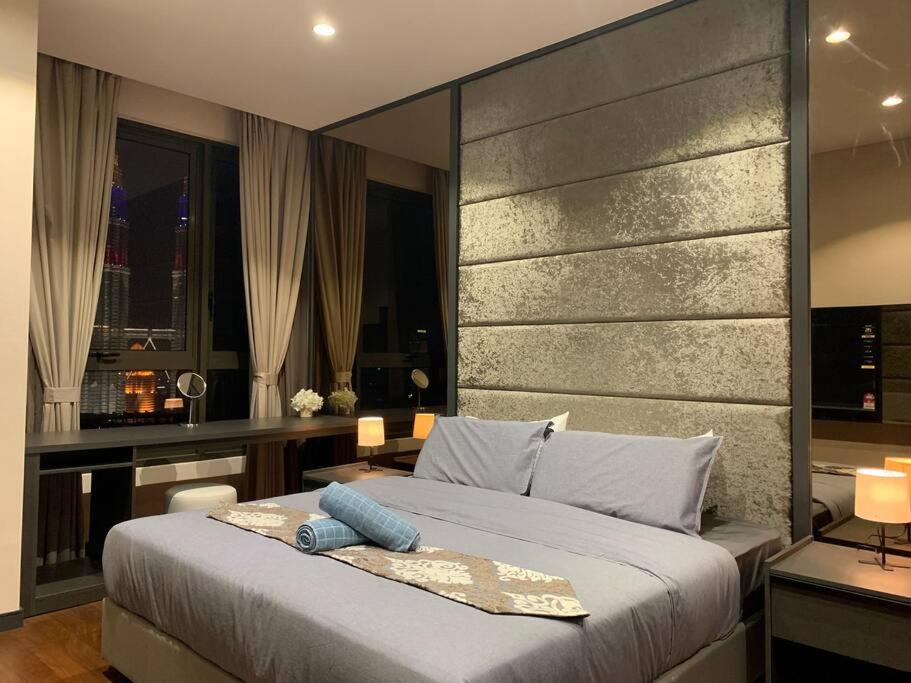 a bedroom with a large bed with a large headboard at Apartment in Bukit Bintang with a clear KLCC view in Kuala Lumpur