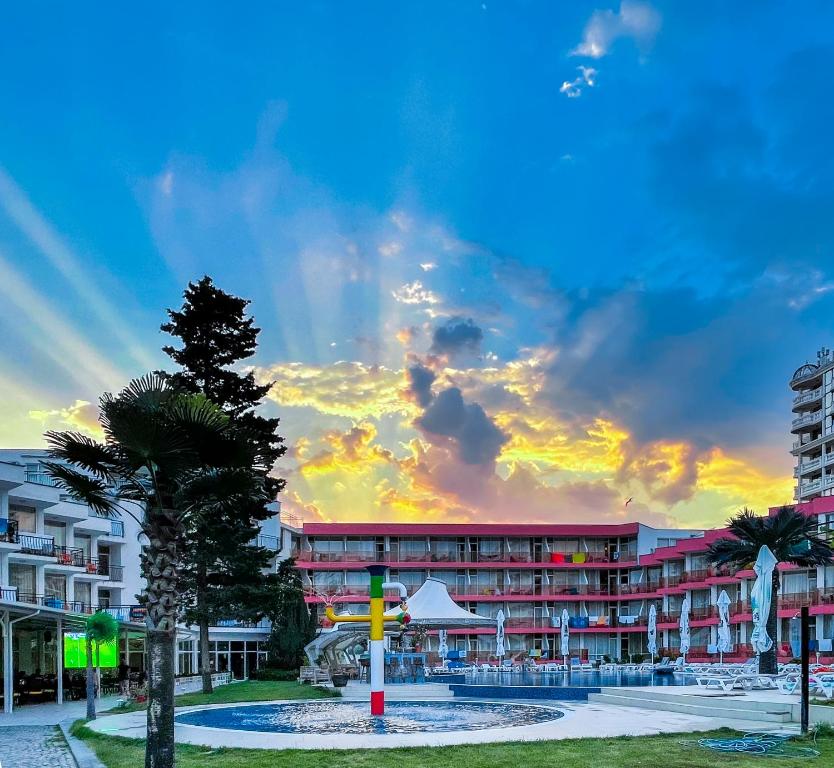 ein Resort mit einer Palme und einem Gebäude in der Unterkunft Flamingo Beach Hotel in Sonnenstrand