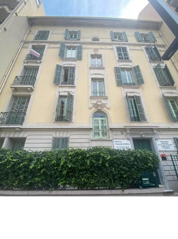 a tall building with many windows on the side of it at studio à 2 mn à pied de la plage in Nice