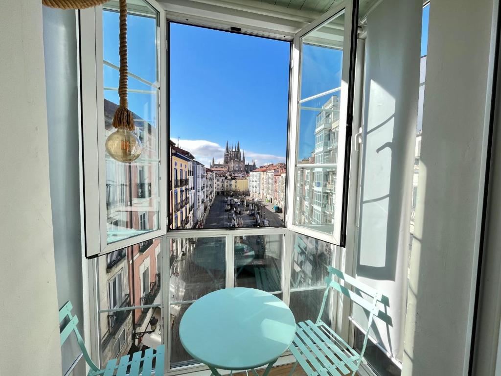 d'un balcon avec un tabouret bleu et une vue sur la ville. dans l'établissement Preciosa vivienda Vistas a la Catedral Parking incluido ATUAIRE, à Burgos