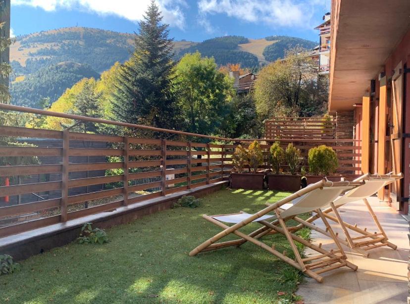 a patio with two lawn chairs and a fence at APARTAMENT LA MOLINA ( ELS CIRERES ) in Alp