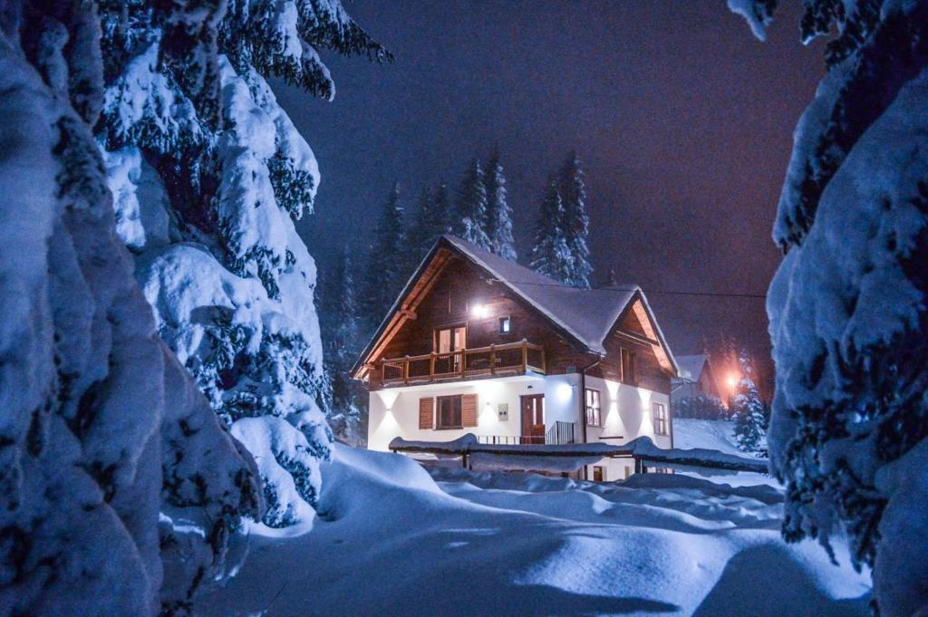 a house in the snow at night at Apartmani Pahulja in Jahorina